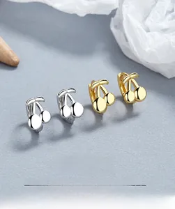 Détail macro de boucles d'oreilles cerise en argent 925 avec finitions dorée et argentée