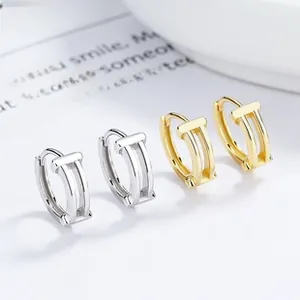 Macro shot of S925 sterling silver N-shaped hoop earrings in gold and silver finish