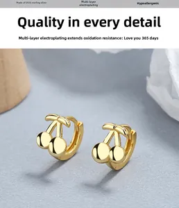 Détail de boucles d'oreilles cerises en argent S925 avec placage en or et anti-allergie