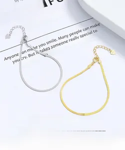 Macro detail of silver and gold snake chain bracelets with S925 heart charm on magazine