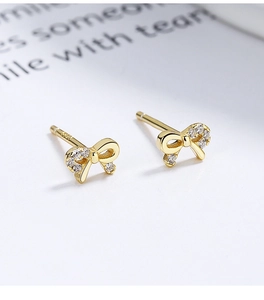 Close-up of S925 sterling silver gold bow stud earrings with sparkling white zircons