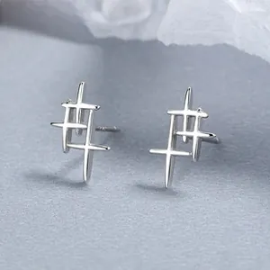 Vue macro des boucles d'oreilles croix en argent 925 avec finition polie et lignes épurées