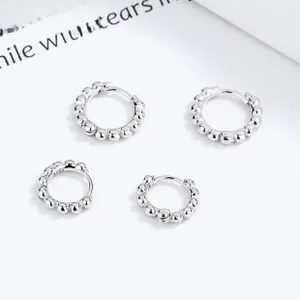 Detail shot showing S925 silver hallmarks on beaded hoop earrings in minimalist style