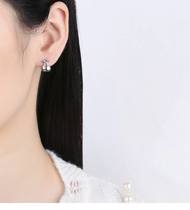 Gros plan de boucles d'oreilles cerise en argent S925 portées par un mannequin chic