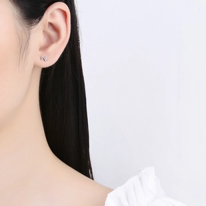 Elegant 925 sterling silver bow knot stud earrings worn by model with minimalist style
