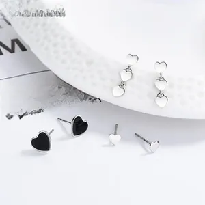Detail view of heart-shaped 925 sterling silver stud earrings in silver and black enamel