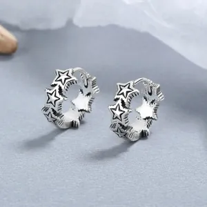 Detail of vintage 925 sterling silver hoop earrings with oxidized five-pointed star pattern