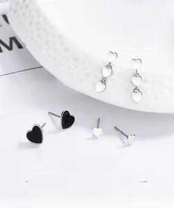 Detail of 925 sterling silver black drip heart studs and triple heart earrings on ceramics