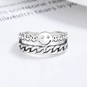 Detail of vintage 925 silver ring featuring smiley face relief and Cuban link chain