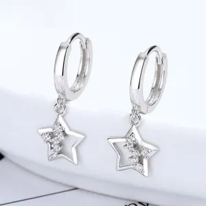 Vista macro di orecchini a stella in argento 925 con zirconi incastonati e design traforato