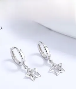 Vista macro degli orecchini a stella in argento 925 con design a incastro e zirconi bianchi