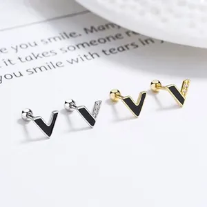Detail of V-shaped stud earrings with black enamel and zircons in gold and silver