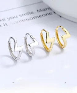 Detailed view of silver and gold lightning bolt hoop earrings with buckle closure