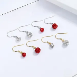 Macro detail of 925 silver soccer ball earrings with pavé crystals in red and silver