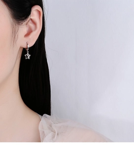 Dettaglio dell'orecchino a stella in argento sterling 925 con diamanti su una modella