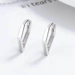 Macro detail of geometric S925 sterling silver hoop earring with visible metal hallmark