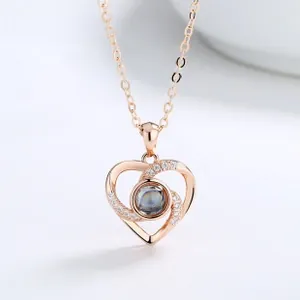 Macro detail of rose gold double heart pendant with white zircons and center projection stone
