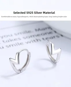 Macro detail of 925 sterling silver geometric V-shaped earrings on a white aesthetic background