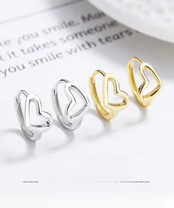 Detail view of S925 sterling silver hollow heart hoop earrings with polished gold and silver finish