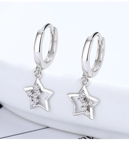 Dettaglio di orecchini a cerchio in argento 925 con stelle traforate e zirconi scintillanti