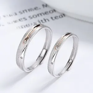 Close-up of Mobius couple rings with frosted silver finish and rose gold accents