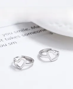 Macro detail of S925 sterling silver hollow heart hoop earrings with polished finish
