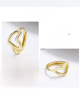Detailed close-up of golden hollow heart hoop earrings featuring polished finish