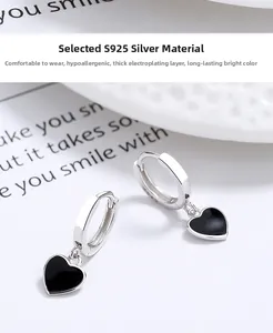 Détail macro des boucles d'oreilles cœur en argent S925 avec émail noir et poinçon