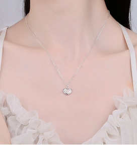 Polished S925 sterling silver heart necklace on a model showing the elegant collarbone fit