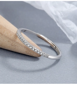 Close-up of adjustable 925 silver ring with sparkling row of diamonds on wooden cone