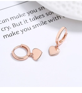 Gros plan du poinçon S925 sur les boucles d'oreilles cœur en argent plaqué or rose