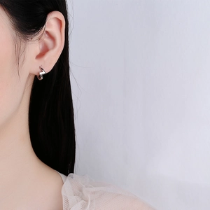 Minimalist 925 sterling silver lightning bolt hoop earrings worn by a model