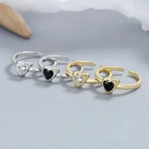 Macro shot of silver and gold plated heart rings with zircon stones on a grey background