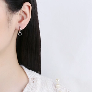 Boucles d'oreilles créoles cœur noir en argent 925 portées par un mannequin élégant