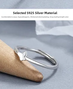 Detail of S925 silver butterfly ring with small zircons on a wooden cone stand