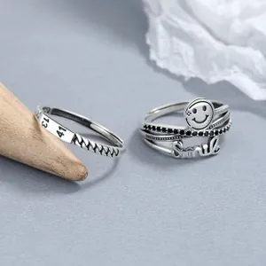 Detailed close-up of retro 925 silver smiley rings set with vintage engraved textures