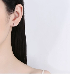 Detailed close-up of 925 silver lightning bolt earring worn on earlobe for visual size reference