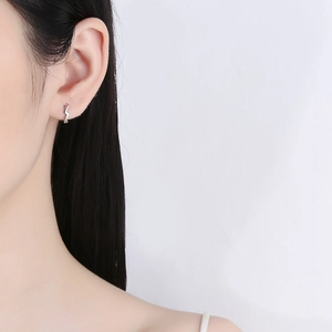 Minimalist 925 sterling silver lightning bolt hoop earrings shown on a female model