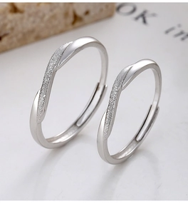 Macro detail of 925 sterling silver couple rings with frosted finish and crossed wave design