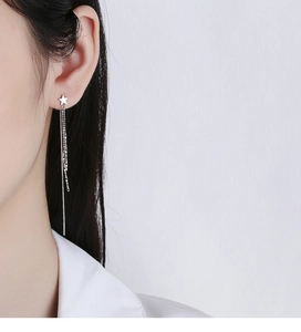 Detail of elegant 925 sterling silver star long tassel earrings worn by a model