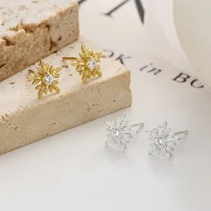 Macro detail of S925 silver snowflake stud earrings with zircon inlay and matte finish