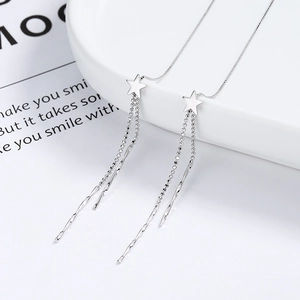 Elegant 925 sterling silver star dangle earrings with long tassels on a ceramic plate