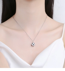 Macro shot of 925 sterling silver football necklace with black and white enamel detail