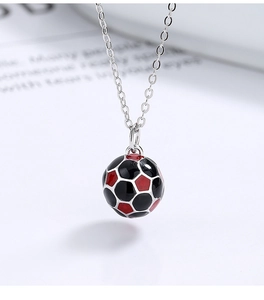 Macro detail of 925 silver football pendant with vibrant black and red enamel finish