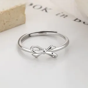 Detailed macro shot of an adjustable S925 sterling silver bow ring on a white stone base