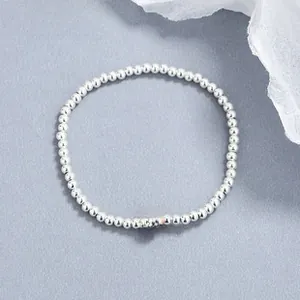 Detailed shot of 925 sterling silver beaded bracelet with a central red agate bead