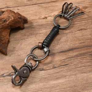 Macro shot of retro braided leather keychain with gunmetal alloy clasp on dark wood
