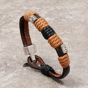 Detail of vintage braided leather bracelet with multi-layer cords and metallic beads