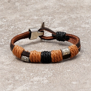 Retro woven leather bracelet with vintage silver beads and T-bar clasp on stone texture