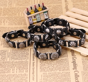 Détail de bracelets en cuir punk avec clous en alliage vintage et breloques industrielles